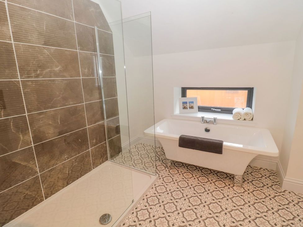 A bathroom with a shower and a bathtub at Harvest Cottage 1 Berwick-upon-Tweed