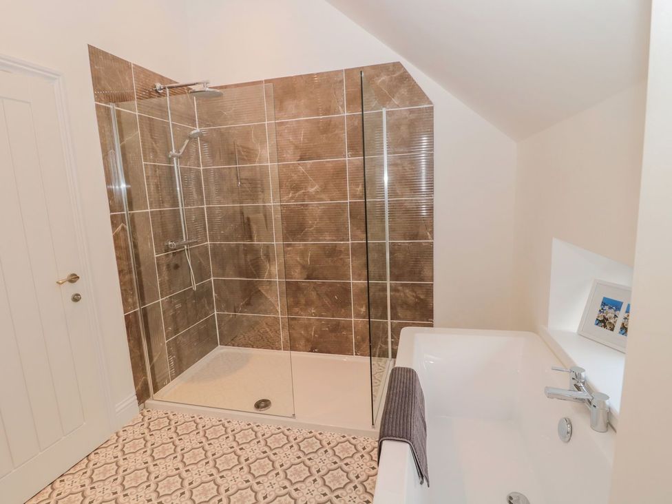 A bathroom with a shower and a bathtub at Harvest Cottage 1 Berwick-upon-Tweed