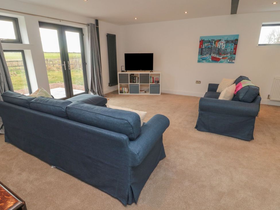 A living room with a sofa and television at Harvest Cottage 2 in Berwick-upon-Tweed