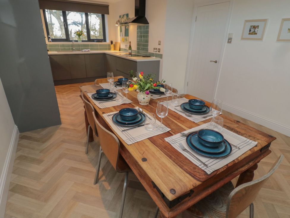 A dining room with a wooden table and dishes at Harvest Cottage 2 Berwick-upon-Tweed