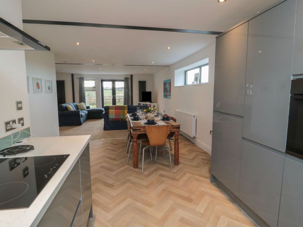 A kitchen with a dining area and living room view at Harvest Cottage 2 in Berwick-upon-Tweed