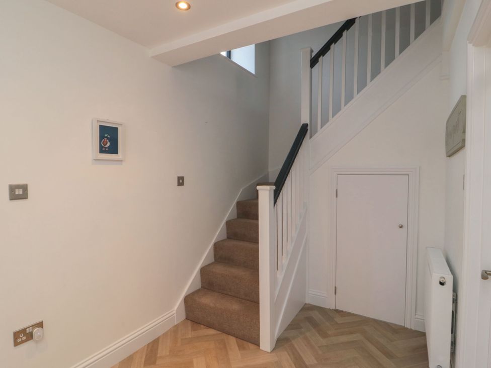 A hallway with stairs and a door at Harvest Cottage 2 in Berwick-upon-Tweed