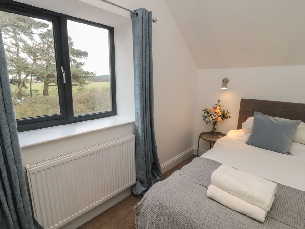 A bedroom with a bed and window at Harvest Cottage 2 Berwick-upon-Tweed