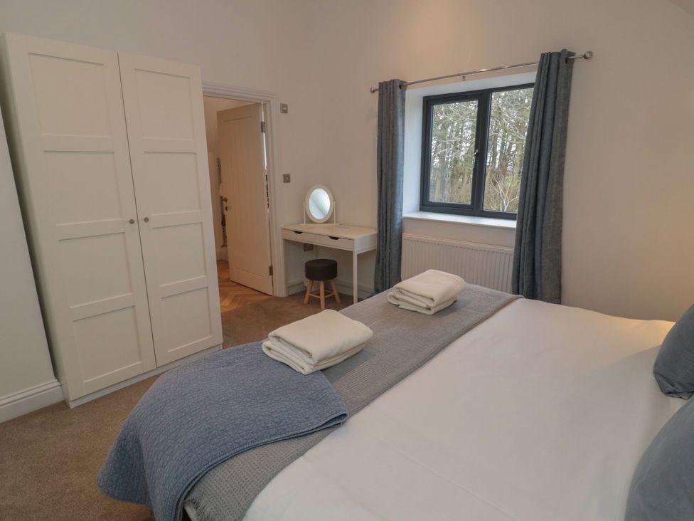A bedroom with a bed and wardrobe at Harvest Cottage 2 in Berwick-upon-Tweed