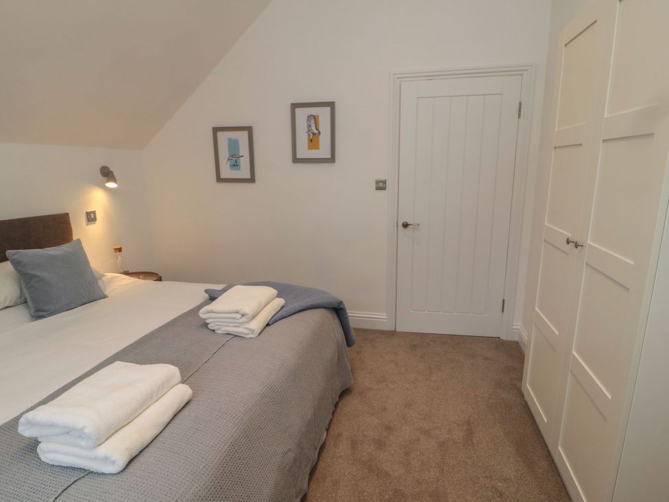 A bedroom with a bed and wall art at Harvest Cottage 2 Berwick-upon-Tweed