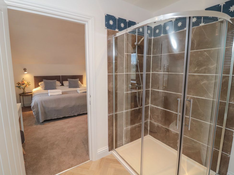 A bathroom with a shower visible and a bedroom in view at Harvest Cottage 2 Berwick-upon-Tweed