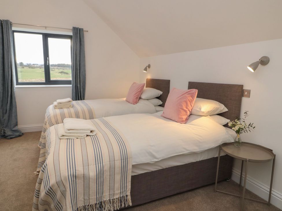 A bedroom with two beds and a window at Harvest Cottage 2 in Berwick-upon-Tweed