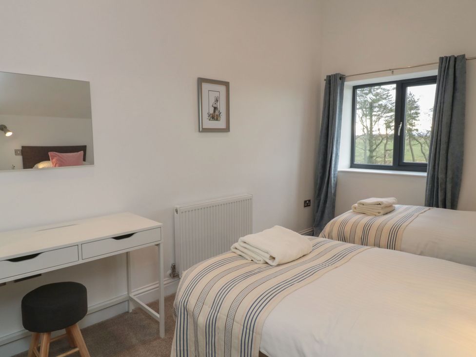 A bedroom with two beds and a desk at Harvest Cottage 2 in Berwick-upon-Tweed