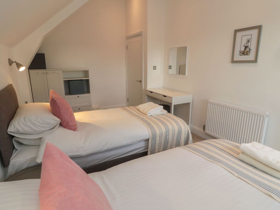 A bedroom with two beds and a dresser at Harvest Cottage 2 Berwick-upon-Tweed