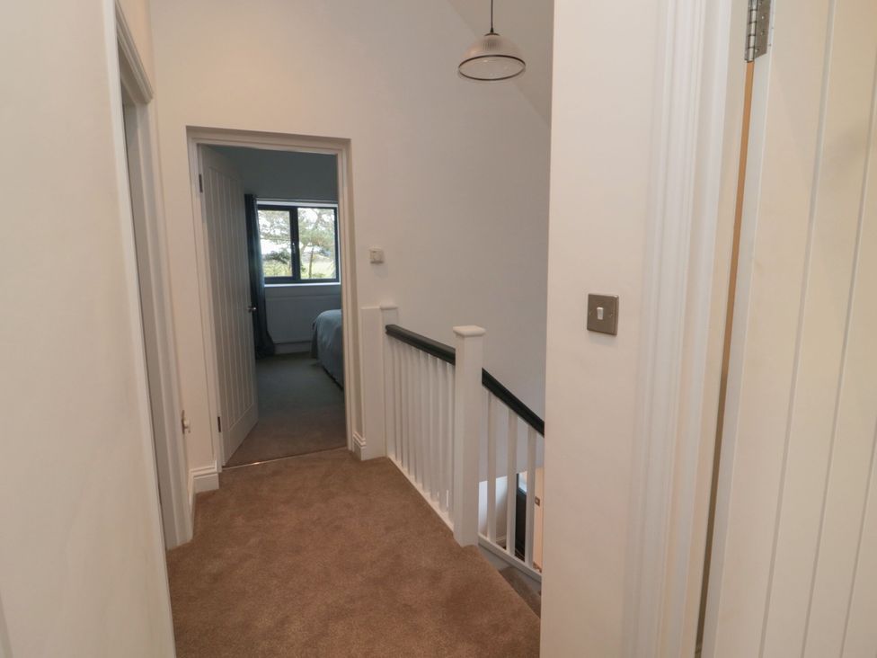 A hallway with staircase and doors at Harvest Cottage 2 in Berwick-upon-Tweed