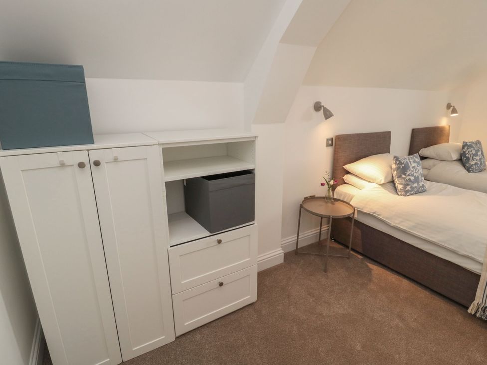 A bedroom with twin beds and storage cabinet at Harvest Cottage 2 Berwick-upon-Tweed