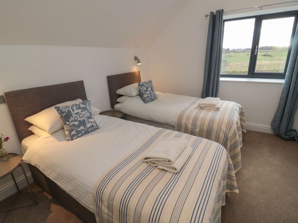 A bedroom with two single beds and a window at Harvest Cottage 2 Berwick-upon-Tweed