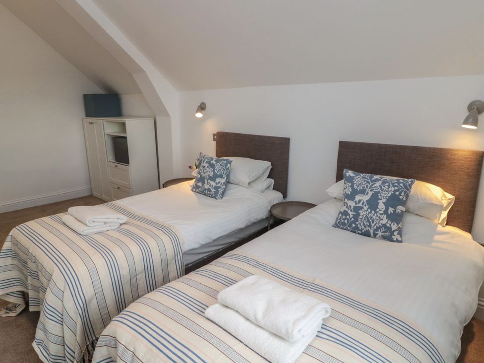 A bedroom with two beds and a dresser at Harvest Cottage 2 Berwick-upon-Tweed