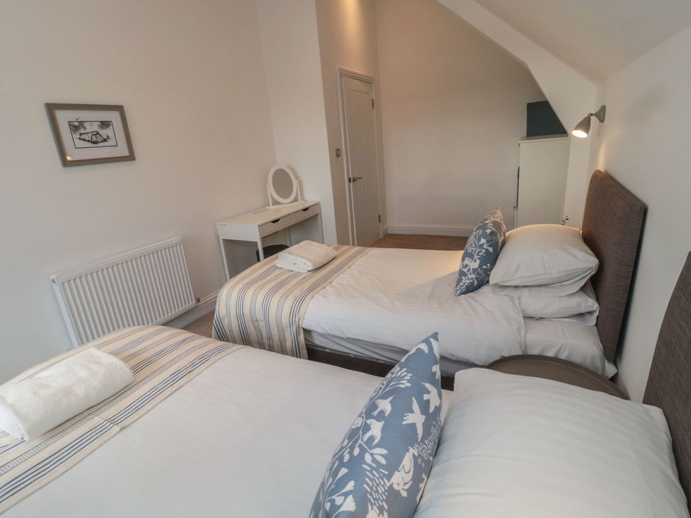 A bedroom with two single beds and a side table at Harvest Cottage 2 in Berwick-upon-Tweed