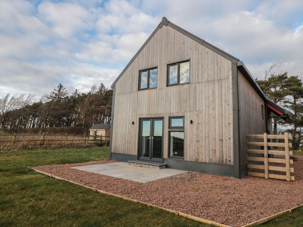 A house with large windows and a patio at Harvest Cottage 2 in Berwick-upon-Tweed