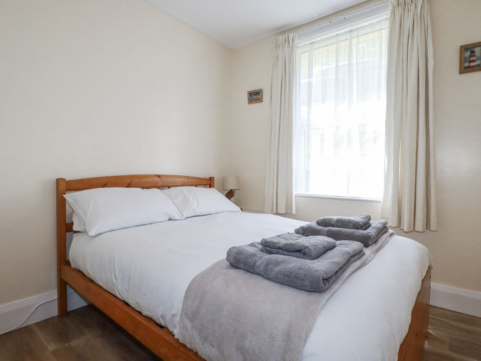 A bedroom with a bed and window at Sea Ledge in Tintagel