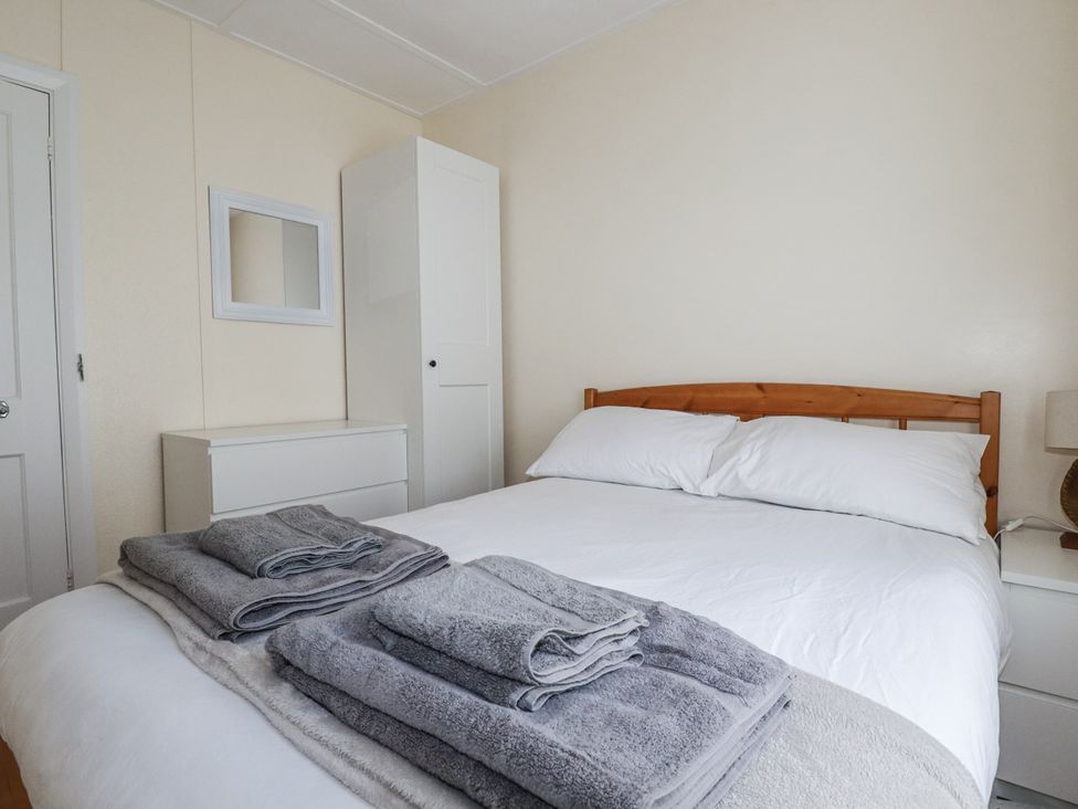 A bedroom with a bed and towels at Sea Ledge in Tintagel