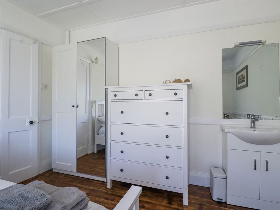 A bedroom with a chest of drawers and a mirror at Sea Ledge in Tintagel