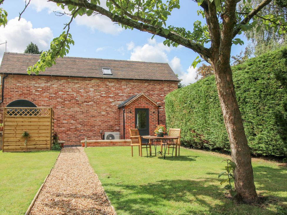 A garden with a table and chairs at Sylva Cottage in Burlton near Cockshutt