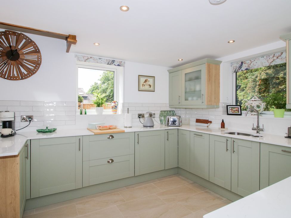 A kitchen with a sink and windows at Sylva Cottage in Burlton near Cockshutt