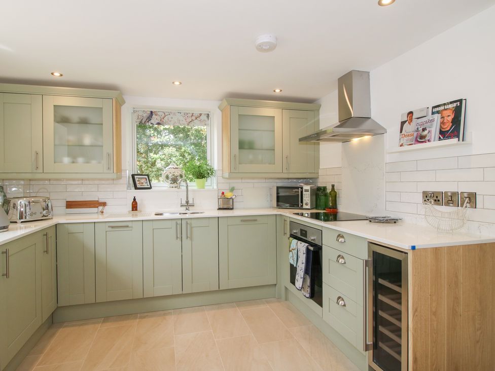 A kitchen with cabinets and appliances at Sylva Cottage in Burlton near Cockshutt