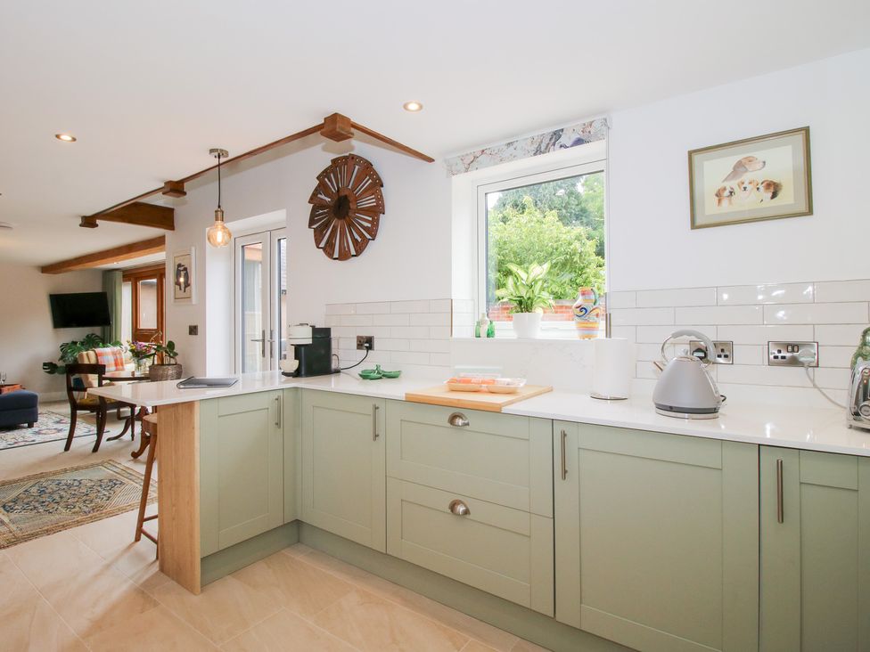 A kitchen with a cutting board and kettle at Sylva Cottage Burlton near Cockshutt