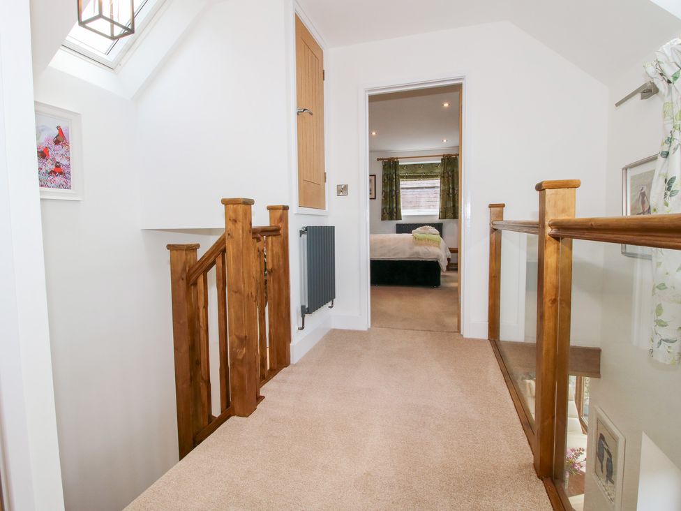 A hallway with a staircase and door at Sylva Cottage Burlton near Cockshutt