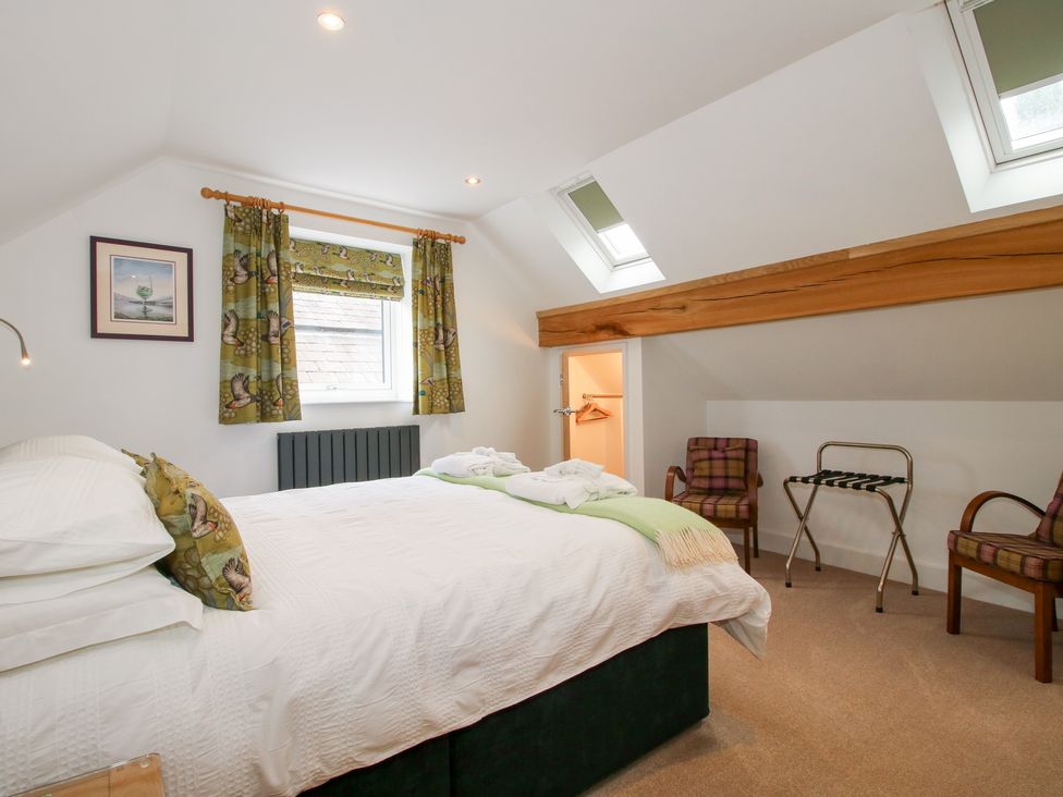 A bedroom with a bed and curtains at Sylva Cottage in Burlton near Cockshutt