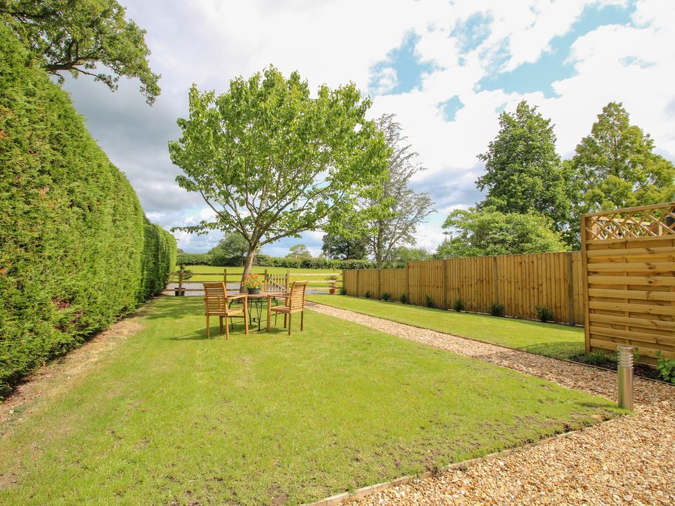 A garden with a table and chairs at Sylva Cottage in Burlton near Cockshutt