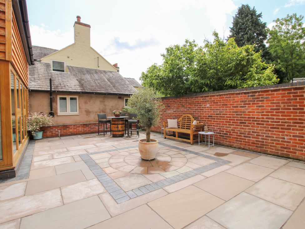 A patio with a table and seating area at Sylva Cottage in Burlton near Cockshutt