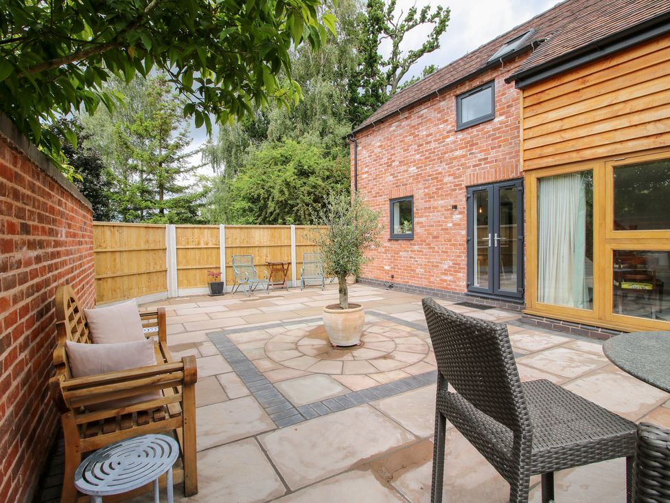 A patio area with seating and plants at Sylva Cottage in Burlton near Cockshutt