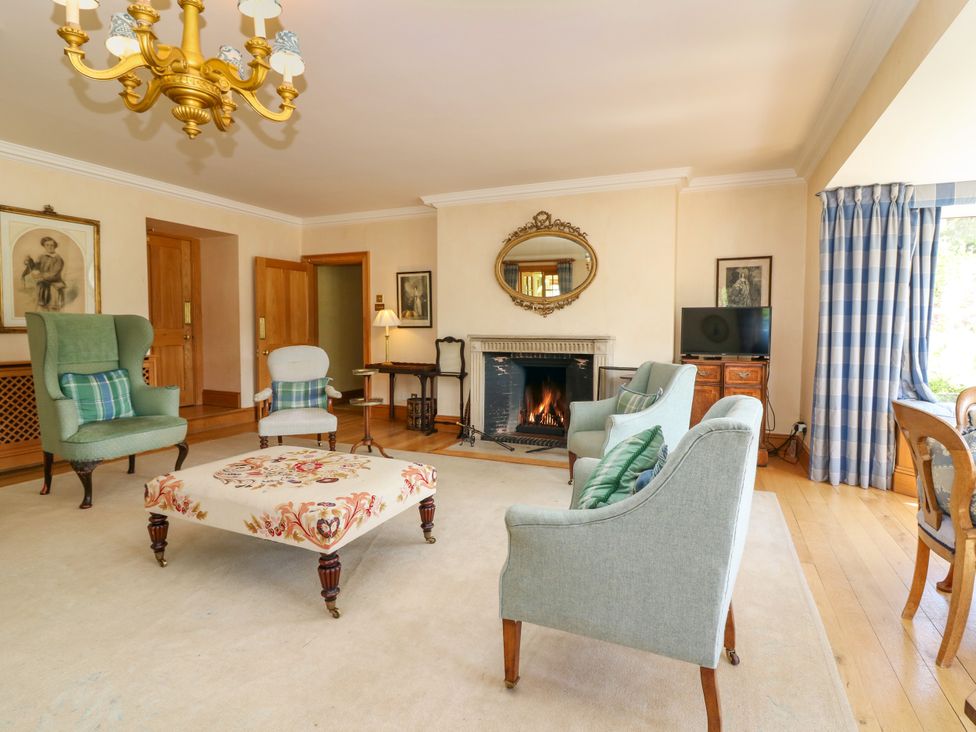 A living room with armchairs and a fireplace at Claybockie near Braemar