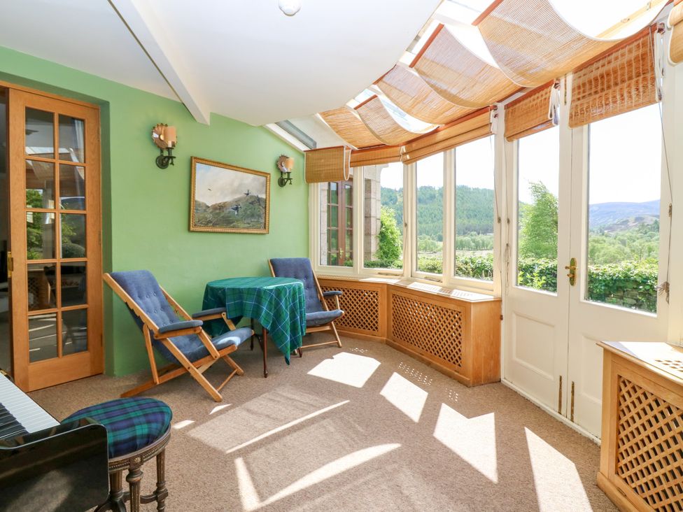 A conservatory with a table and chairs at Claybockie near Braemar