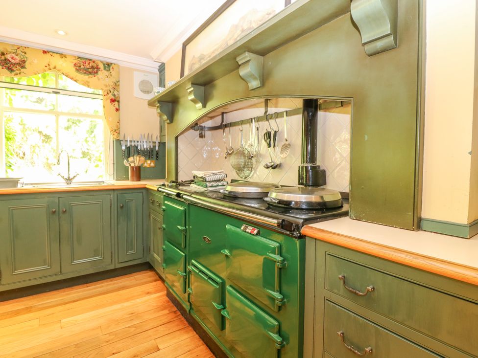 A kitchen with a green cooking range and utensils at Claybockie Mar Lodge near Braemar