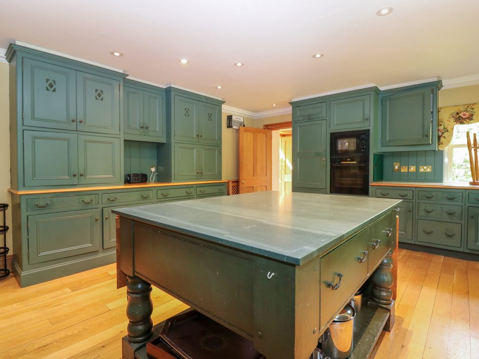 A kitchen with cabinets and an island at Claybockie near Braemar