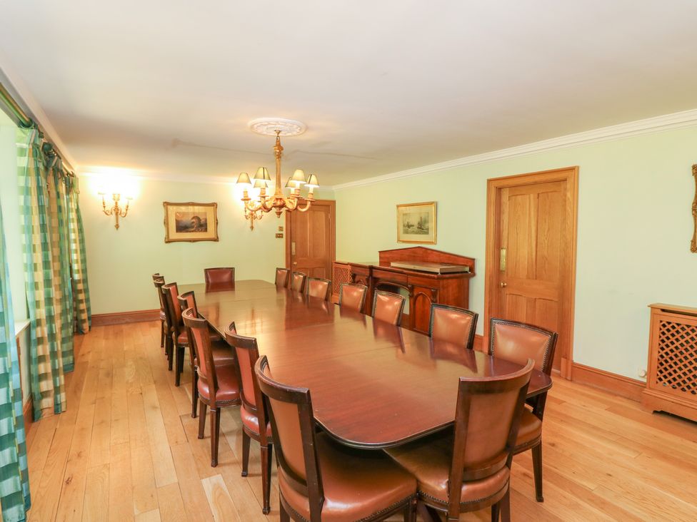 A dining room with a long table and chairs at Claybockie near Braemar