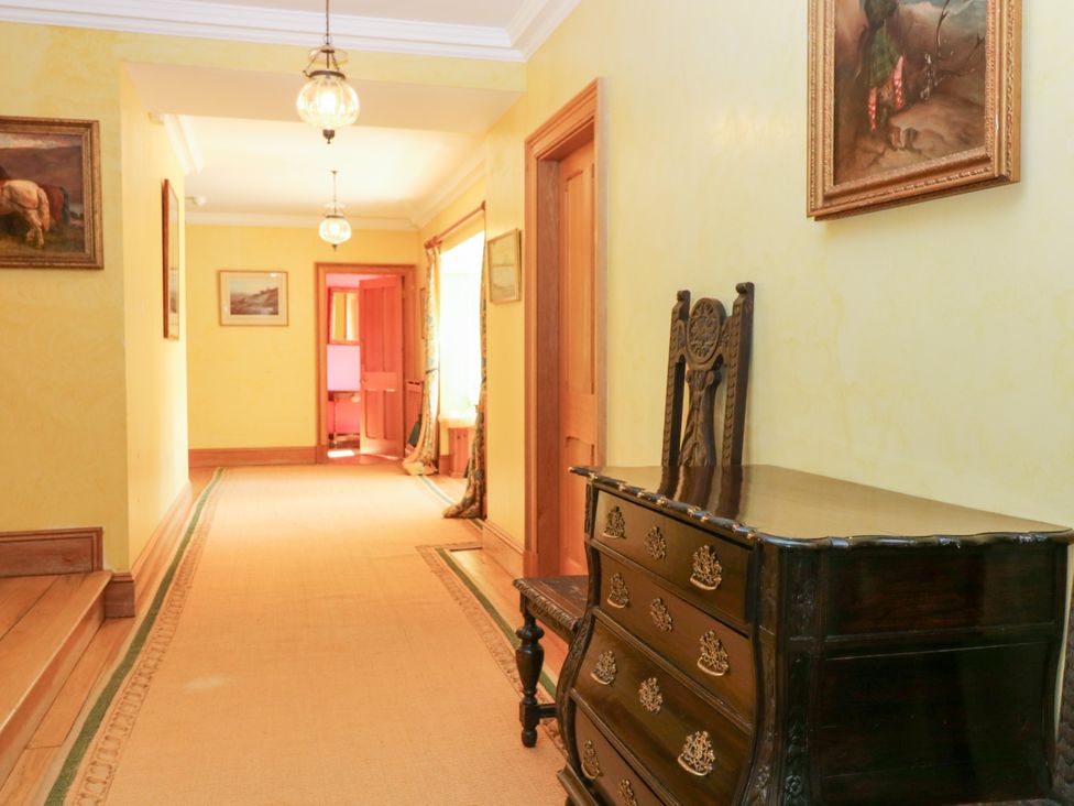 A hallway with a chest of drawers and paintings at Claybockie near Braemar