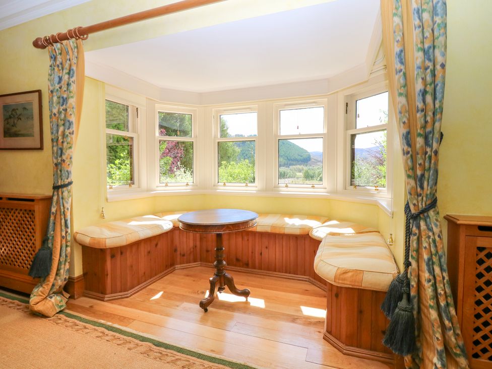 A snug with windows and a table at Claybockie in Mar Lodge near Braemar