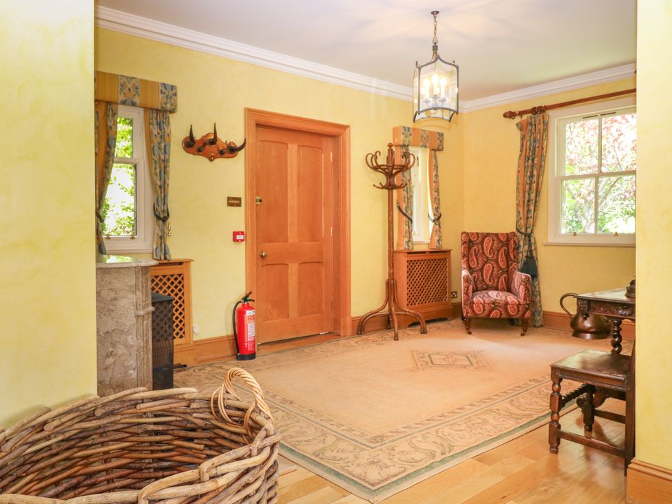 A hallway with a coat rack and chair at Claybockie near Braemar