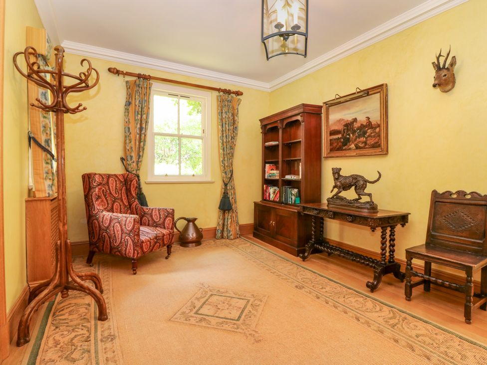 A snug with a chair, table and bookshelf at Claybockie near Braemar