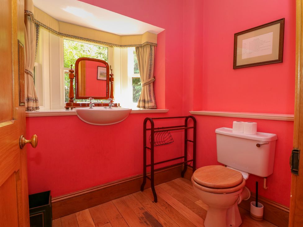 A bathroom with a sink, toilet, and mirror at Claybockie Mar Lodge near Braemar