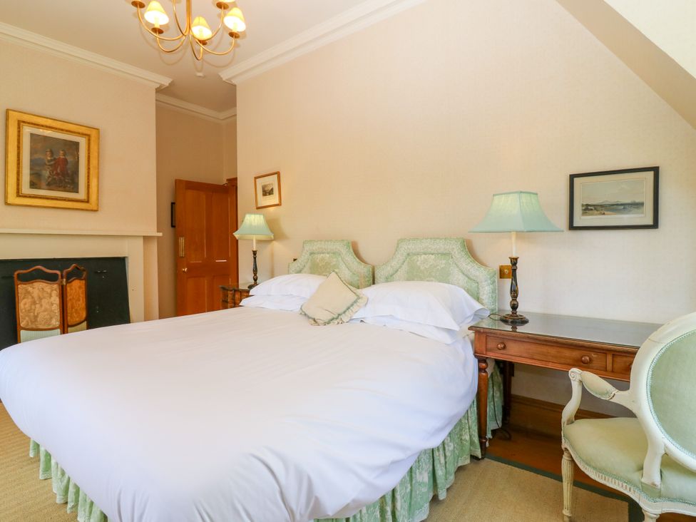 A bedroom with a bed, table, and lamp at Claybockie in Mar Lodge near Braemar