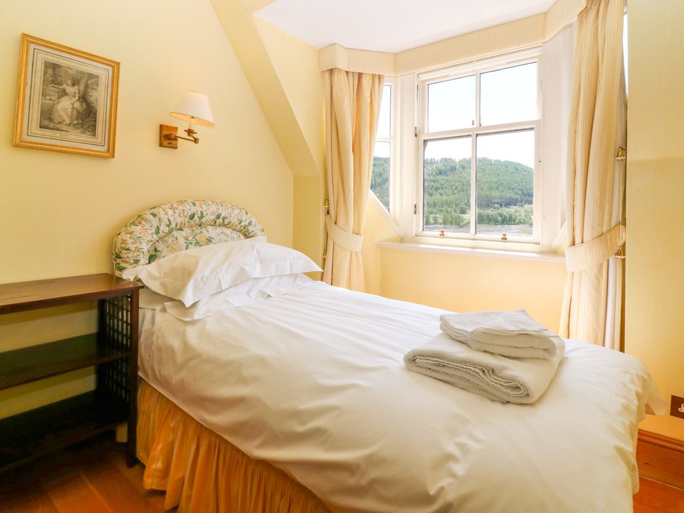 A bedroom with a bed and nightstand at Claybockie near Mar Lodge Braemar