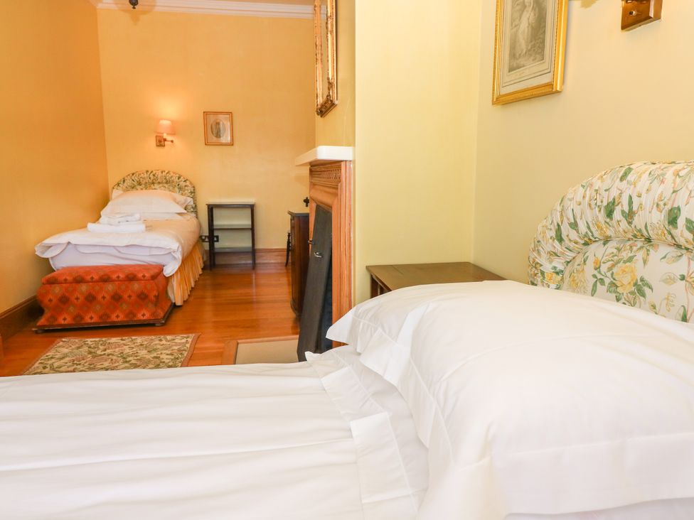 A bedroom with two beds and a bedside table at Claybockie near Mar Lodge Braemar