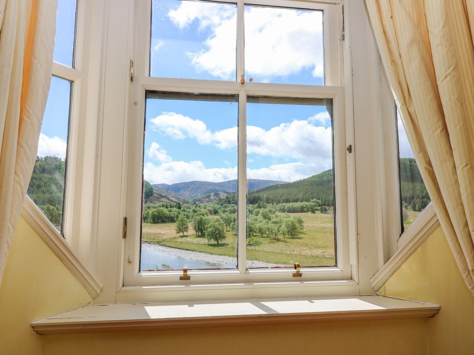 A window view of mountains and a river at Claybockie, Mar Lodge near Braemar