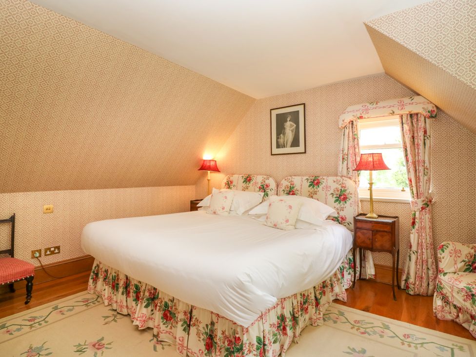 A bedroom with a double bed and lamps at Claybockie near Braemar