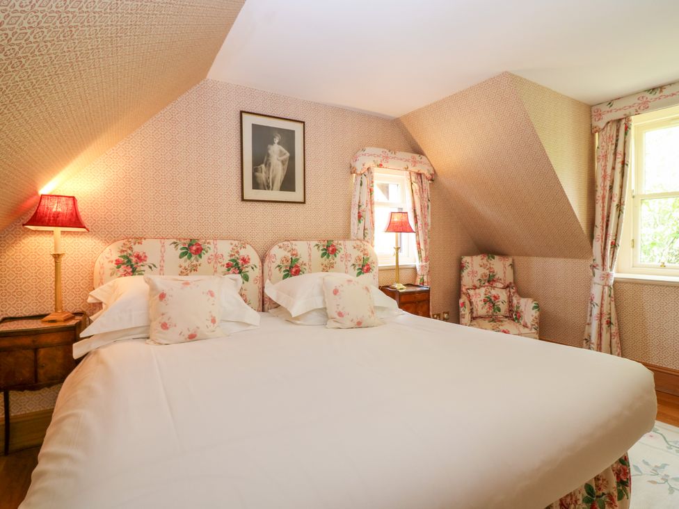 A bedroom with a bed and a chair at Claybockie in Mar Lodge near Braemar