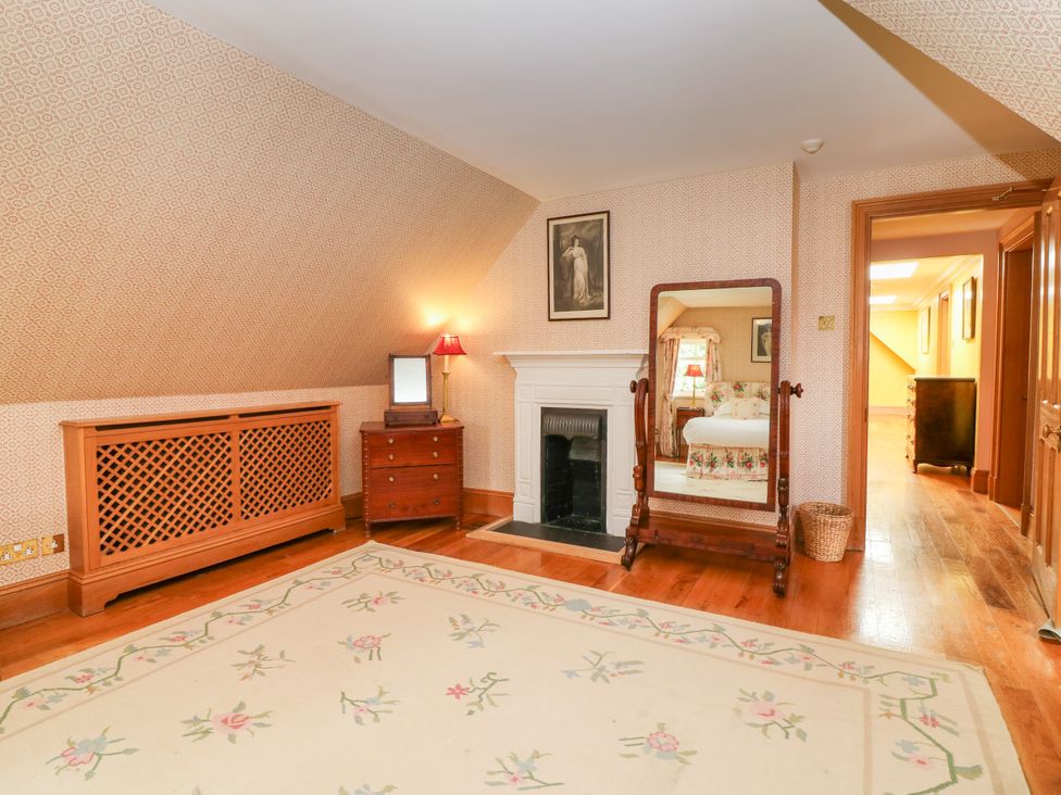 A bedroom with a mirror and lamp at Claybockie near Braemar