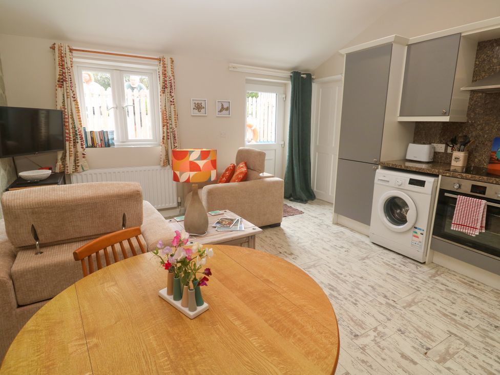 A living room with a sofa and television at The Stable in Rosudgeon
