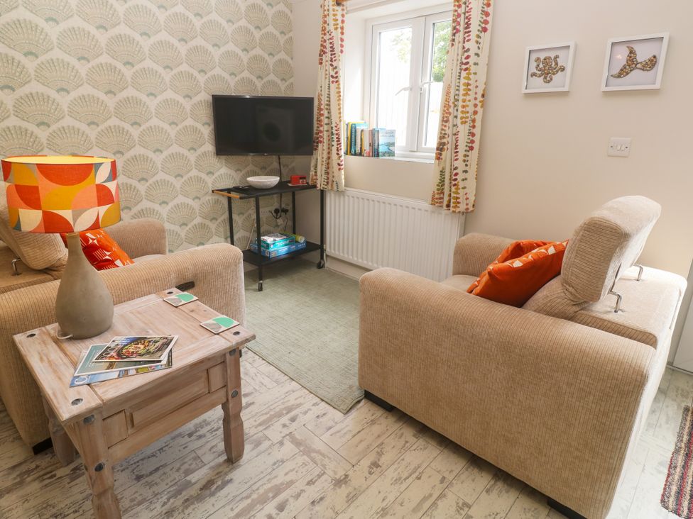 A living room with a television and sofa at The Stable in Rosudgeon